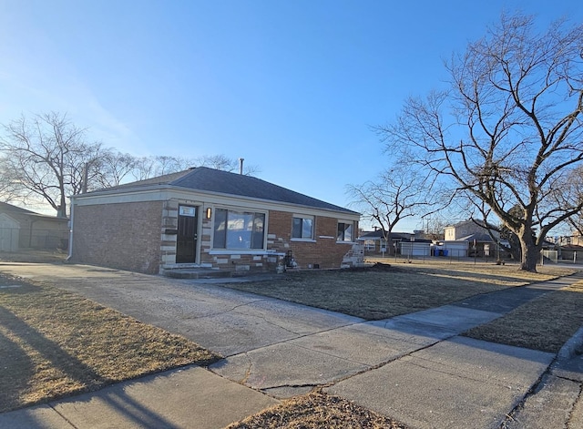 view of front of property with brick siding, a front lawn, and fence