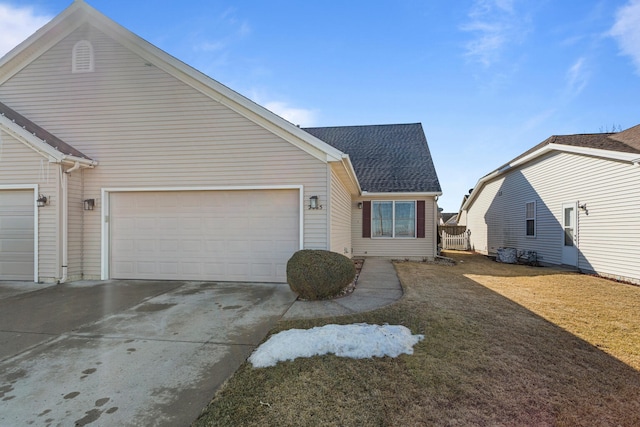 view of front facade featuring a garage, a front lawn, concrete driveway, and roof with shingles