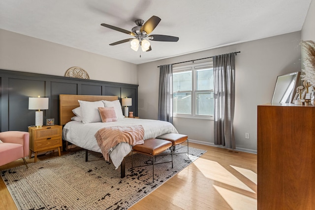 bedroom featuring light wood-style floors, ceiling fan, and baseboards