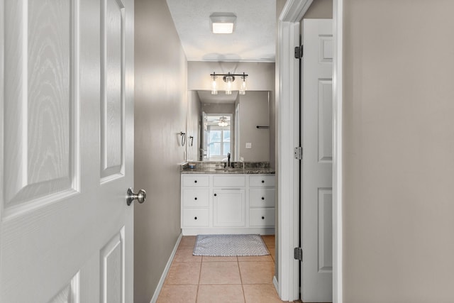 bathroom featuring ceiling fan, vanity, a textured ceiling, baseboards, and tile patterned floors