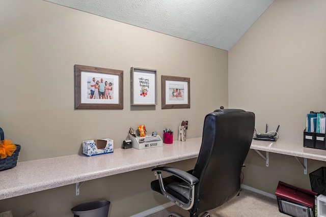 office with light carpet, baseboards, lofted ceiling, a textured ceiling, and built in desk