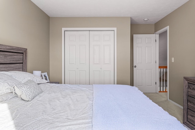 bedroom with carpet floors, baseboards, and a closet