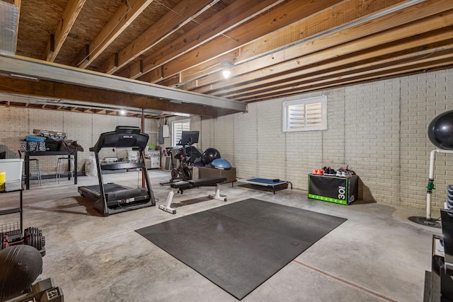 exercise area with electric panel and brick wall