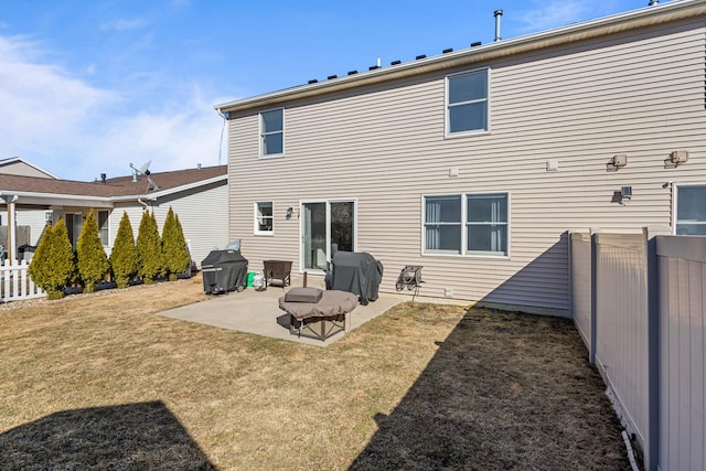 rear view of house featuring a yard, a patio, and fence