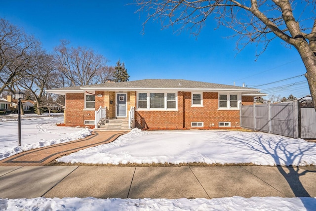 view of front of house featuring a gate, brick siding, and fence