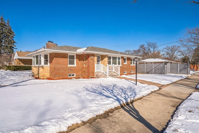 view of front of home featuring a gazebo, brick siding, and a chimney