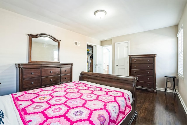 bedroom with dark wood finished floors, visible vents, and baseboards