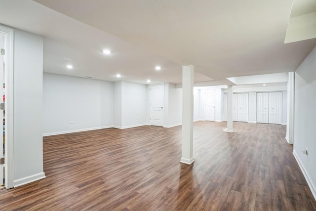 finished below grade area featuring recessed lighting, dark wood finished floors, and baseboards