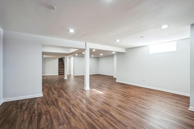 basement featuring dark wood-style floors, recessed lighting, baseboards, and stairs