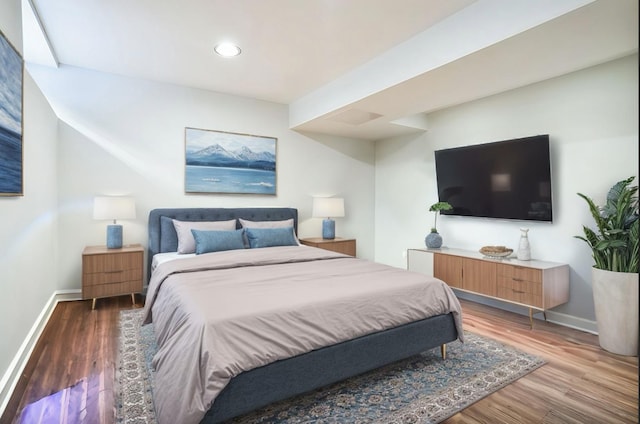 bedroom with recessed lighting, wood finished floors, and baseboards