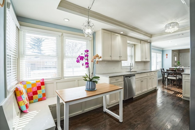 kitchen with decorative light fixtures, a raised ceiling, ornamental molding, a sink, and dishwasher