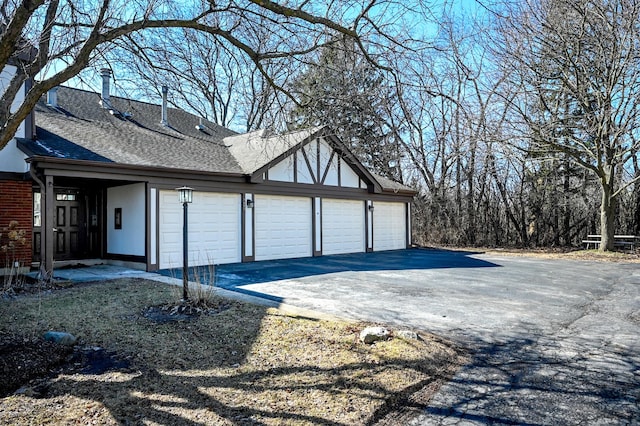 exterior space featuring a garage and roof with shingles