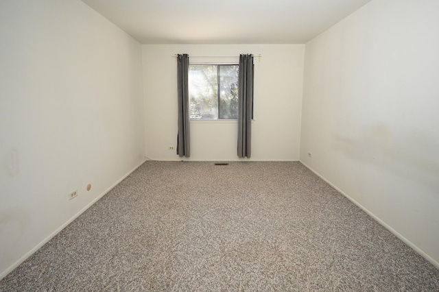 unfurnished room with carpet floors and baseboards