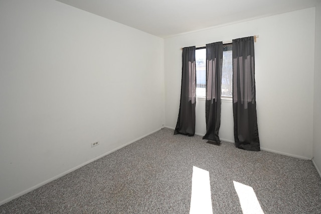 carpeted spare room with baseboards