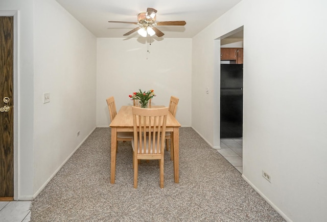 dining area with light colored carpet, ceiling fan, baseboards, and light tile patterned floors