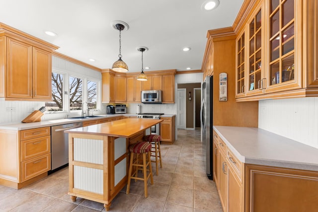 kitchen featuring a sink, stainless steel appliances, a kitchen island, and light countertops