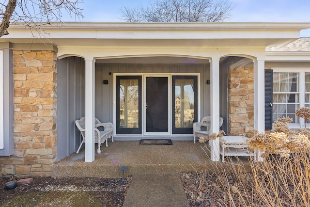 property entrance featuring stone siding and a porch