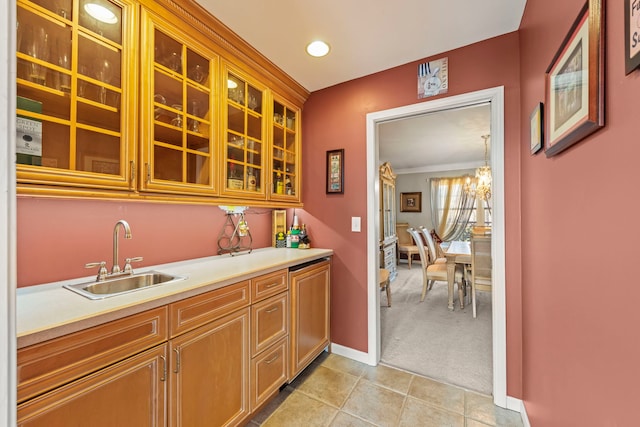 bar featuring baseboards, light tile patterned floors, light carpet, an inviting chandelier, and a sink