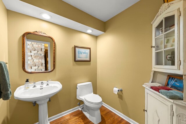 bathroom with recessed lighting, baseboards, toilet, and wood finished floors