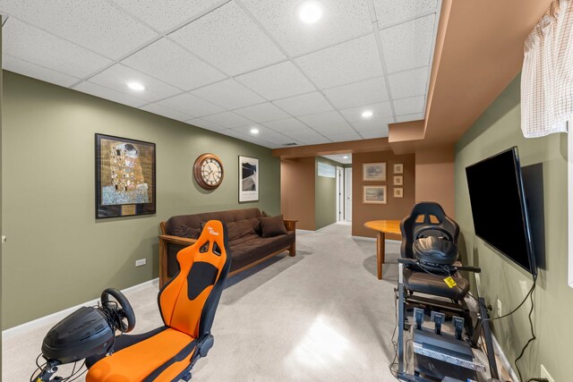 carpeted living area featuring a drop ceiling, recessed lighting, and baseboards