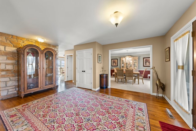 entrance foyer with a chandelier, baseboards, and wood finished floors