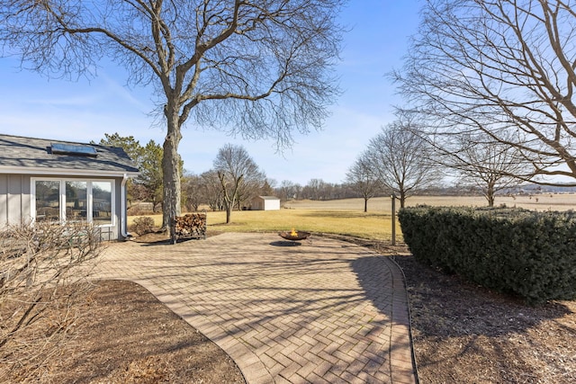 view of yard featuring a shed, a patio, an outdoor fire pit, and an outdoor structure