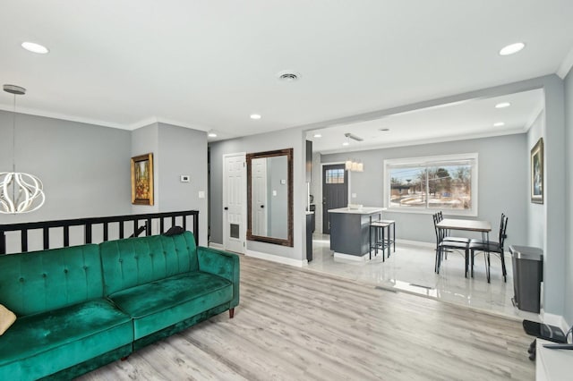 living room with crown molding, baseboards, visible vents, and an inviting chandelier