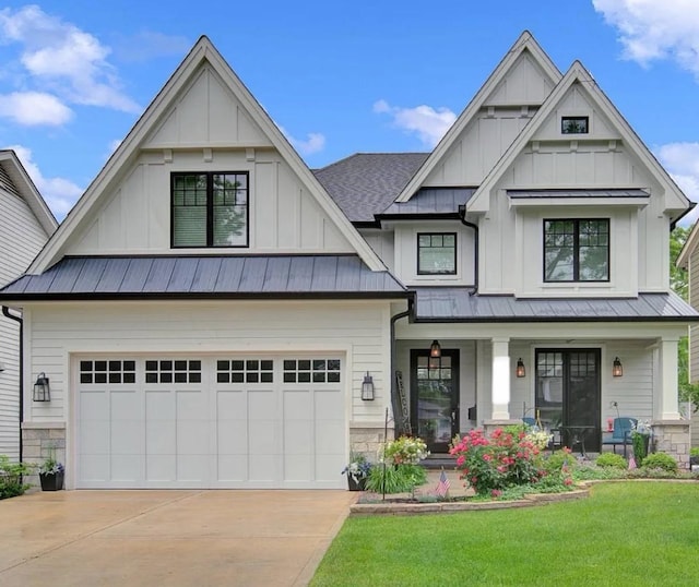 view of front of home featuring concrete driveway, metal roof, a standing seam roof, board and batten siding, and a front yard