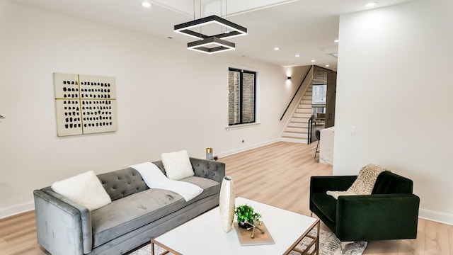 living area featuring stairs, baseboards, light wood-style flooring, and recessed lighting