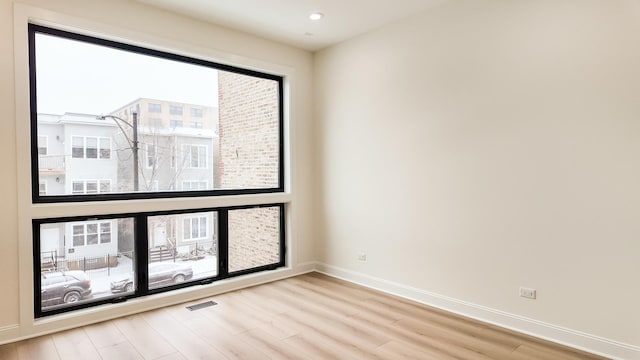 unfurnished room with light wood finished floors, visible vents, baseboards, and recessed lighting