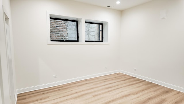 empty room featuring light wood finished floors, visible vents, baseboards, and recessed lighting