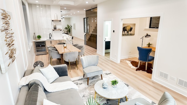 living room featuring beverage cooler, light wood-style flooring, visible vents, and recessed lighting