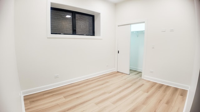 empty room with light wood-style floors and baseboards