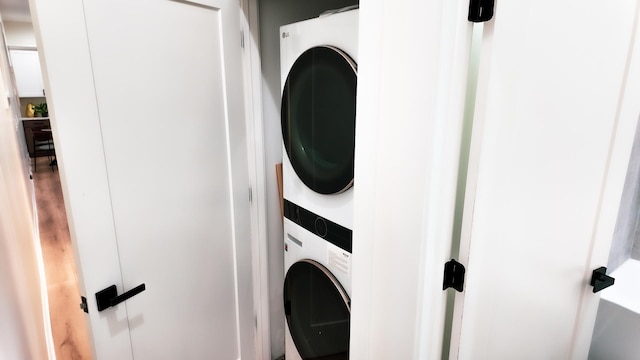 washroom with stacked washer and clothes dryer and laundry area