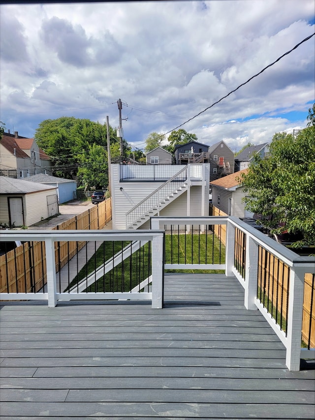 wooden deck featuring a residential view, fence, and stairs