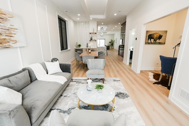 living room featuring baseboards, visible vents, light wood-style flooring, and recessed lighting