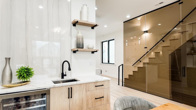 bar featuring visible vents, wine cooler, stairway, light wood-type flooring, and a sink