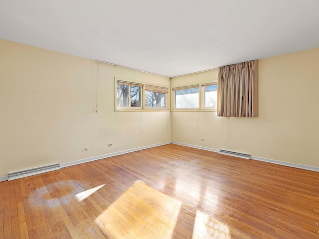 spare room featuring visible vents, light wood-style flooring, and baseboards