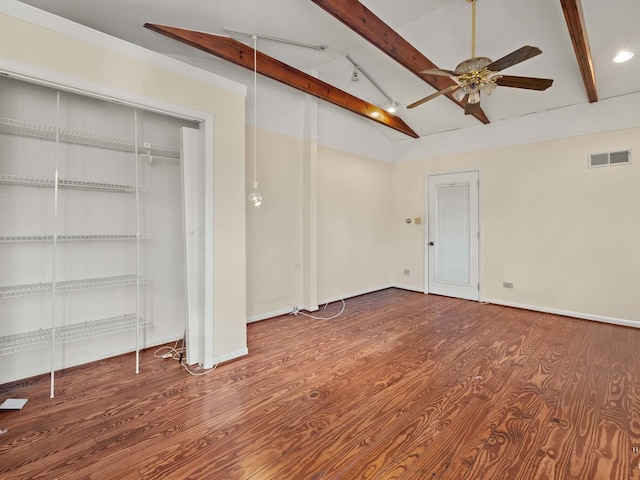 unfurnished bedroom with lofted ceiling with beams, wood finished floors, visible vents, and baseboards