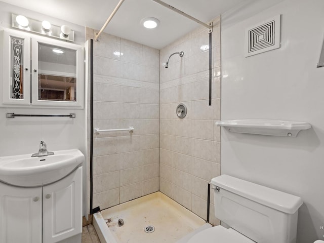 bathroom with toilet, a stall shower, and vanity