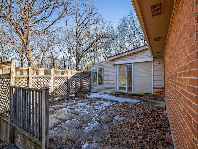 exterior space with visible vents and fence