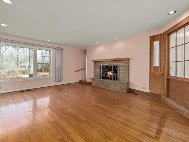 unfurnished living room featuring visible vents, a fireplace, light wood-style flooring, and recessed lighting