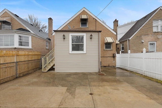 rear view of property featuring a patio area and fence