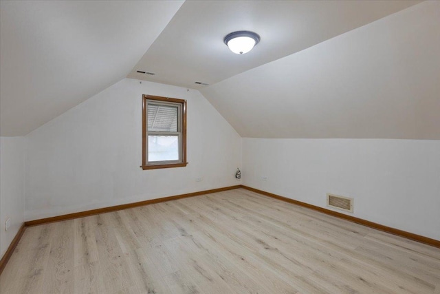 additional living space featuring vaulted ceiling, visible vents, baseboards, and wood finished floors