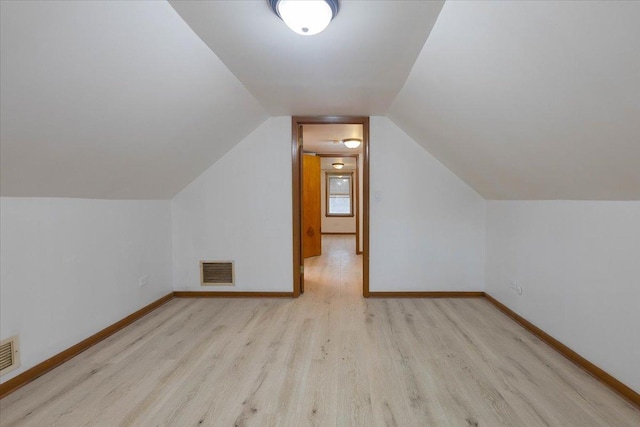 bonus room with lofted ceiling, wood finished floors, visible vents, and baseboards