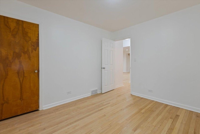 unfurnished room featuring visible vents, light wood-style flooring, and baseboards