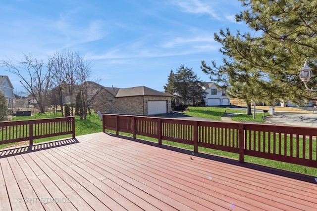 wooden deck with a garage, a residential view, and a lawn