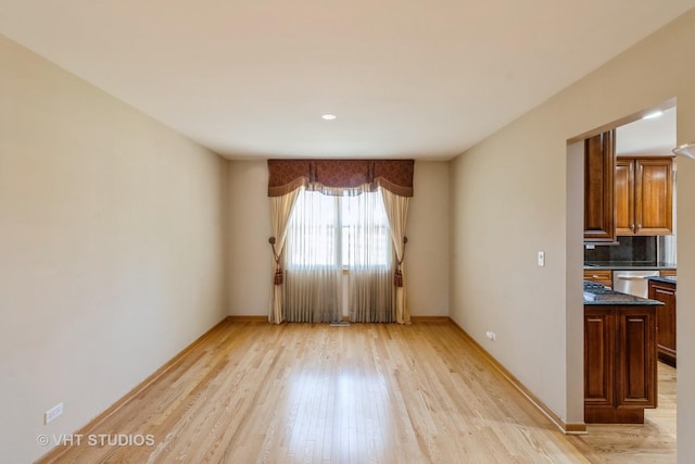 interior space featuring baseboards and light wood finished floors