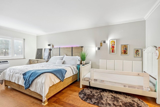 bedroom with crown molding and wood finished floors