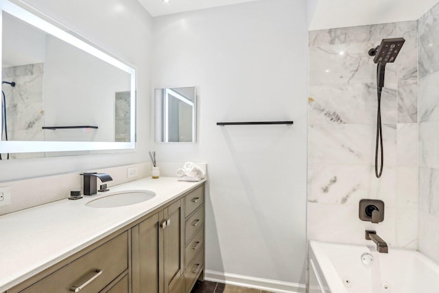 full bath featuring a combined bath / shower with jetted tub, vanity, and baseboards